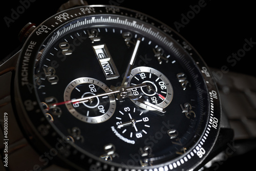 Luxury quartz chronograph watch on a black background, close-up