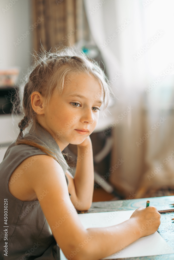 A 6-7-year-old girl at home draws at home with pencils A 6-7-year-old girl at home draws at home with pencils