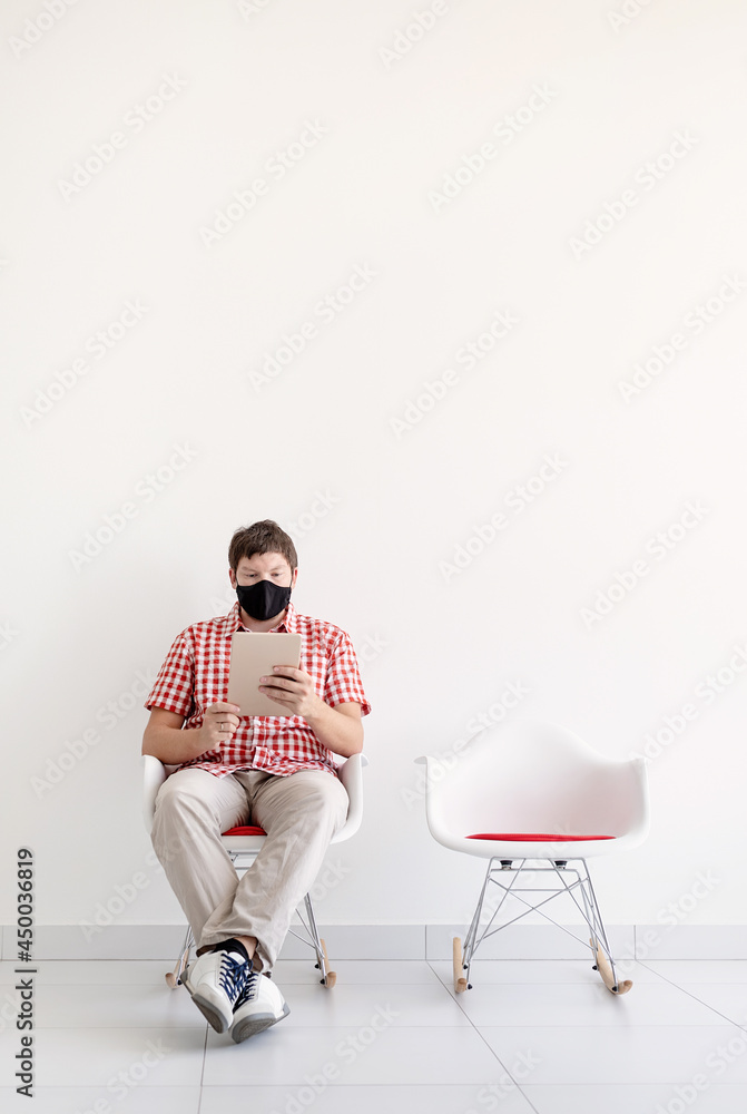 Young man in protective mask studying online keeping social distance Young man in protective mask studying online keeping social distance