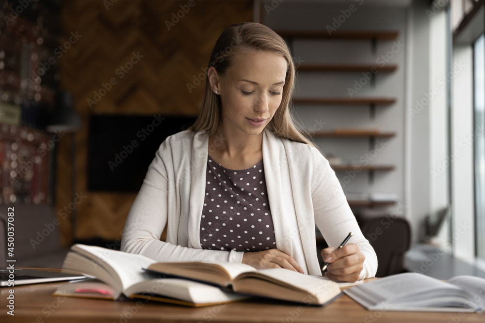 Serious college or internship student studying heap of books, writing summary, taking notes at work table, doing homework, research, improving professional skills, getting knowledge, occupation Serious college or internship student studying heap of books, writing summary, taking notes at work table, doing homework, research, improving professional skills, getting knowledge, occupation