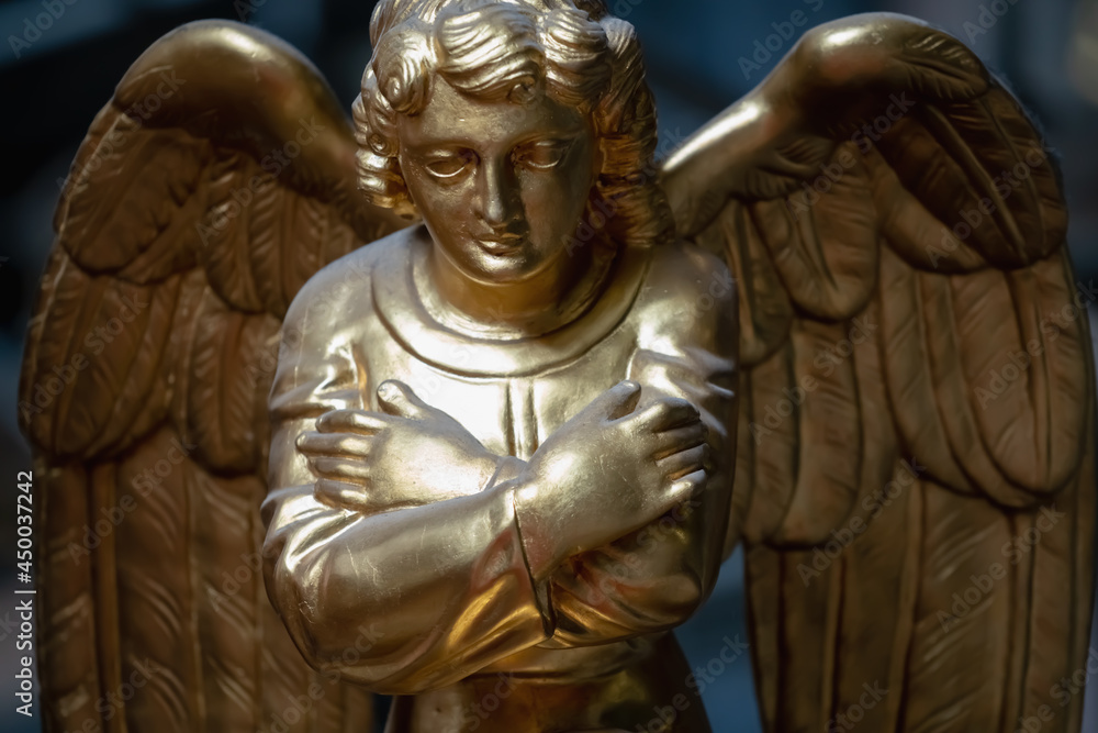 Praying angel. Close up fragment of an ancient statue.