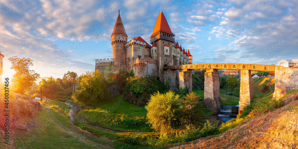 hunedoara, romania - OCT 13, 2019: corvin castle at sunrise. panoramic view of medieval fortification in morning light. one of the most beautiful landmarks in transylvania. popular travel destination