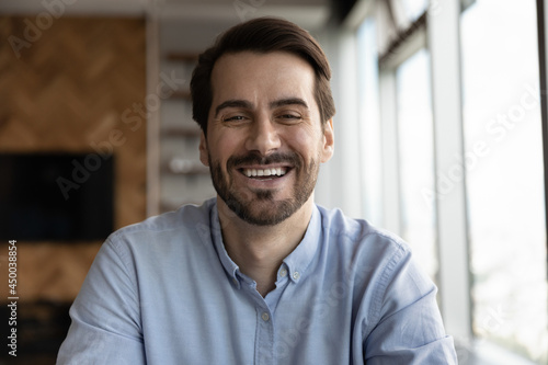 Happy 30s business man, professional, leader, entrepreneur in casual looking at camera, speaking, smiling. Teacher giving webinar via conference video call. Head shot portrait, screen view