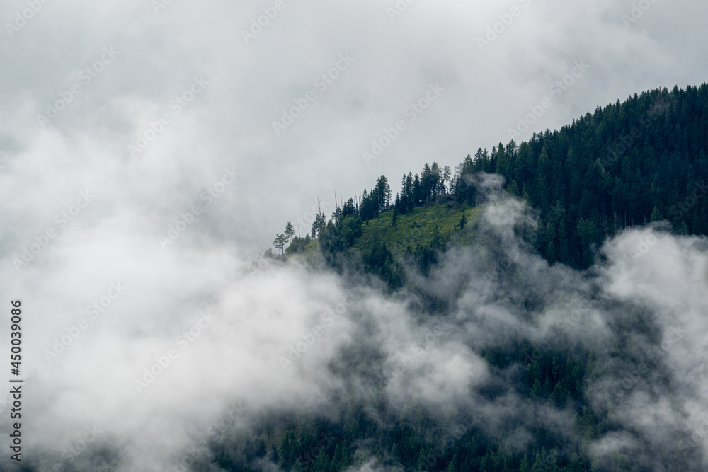 low hanging clouds in the mountains at a summer day