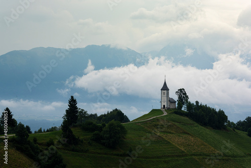 St Primoz Church in Jamnik Sovenia on Hill Top In Clouds