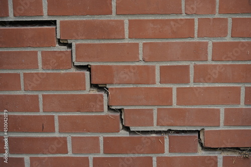 Brick garage wall with cracks, caused by subsidence of the wall. Hanover, Germany. 
