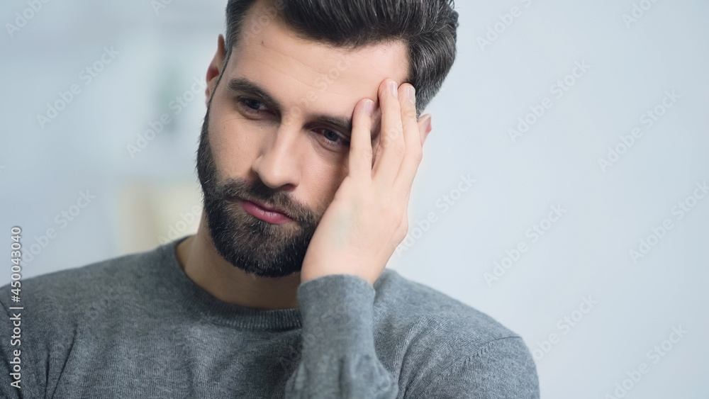 stressed and bearded man touching face at home stressed and bearded man touching face at home