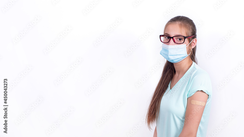 Teenage girl in mask with Band-Aid on shoulder after vaccination against coronavirus or flu. Mandatory prevention for young people for immunity from virus. person isolated on white background. Banner.