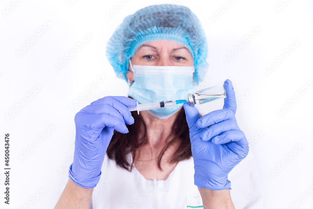 female doctor in protective mask and gloves is typing vaccine into syringe. Close-up. virologist scientist. Prevention against influenza, virus pandemic, coronavirus. Mandatory vaccination of people.