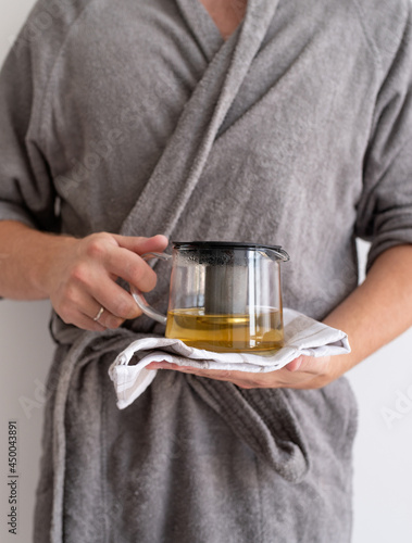 Close up of man hands holding teapot with green tea
