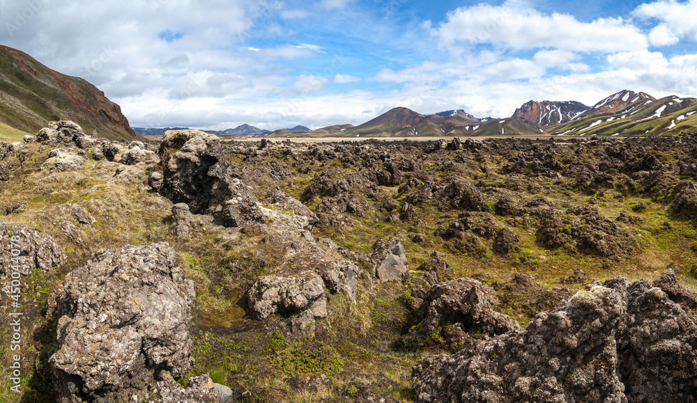 Volcanic stony landscape and frozen lava by moss at Landmannalaugar, Iceland