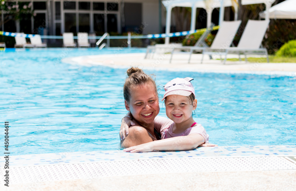 portrait of mom and daughter in the pool