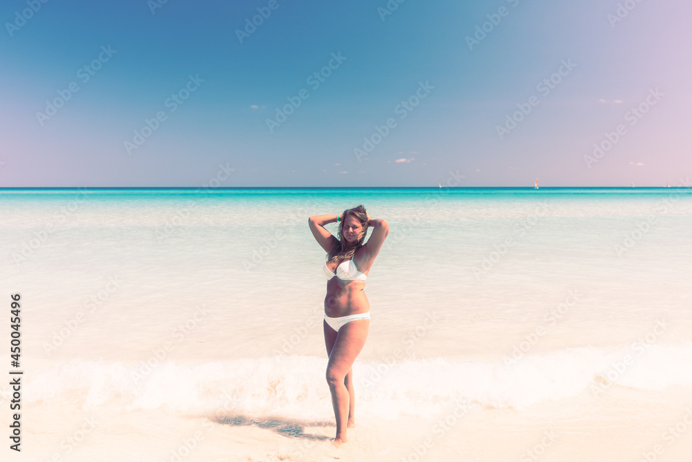 Portrait of a tanned girl on the beach in a swimsuit