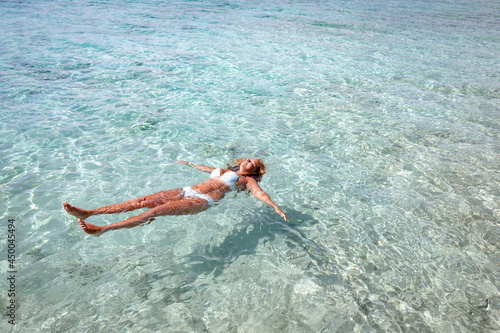Girl swims in crystal clear and transparent water