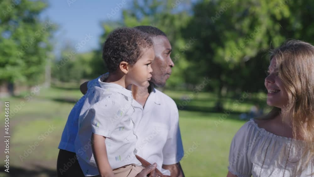 A multinational family is walking in the park. African American father with his wife and child. A multinational family is walking in the park. African American father with his wife and child.