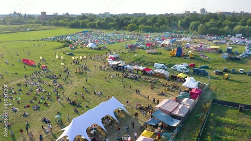 Concert on a meadow with tents on the background of the city, river and castle