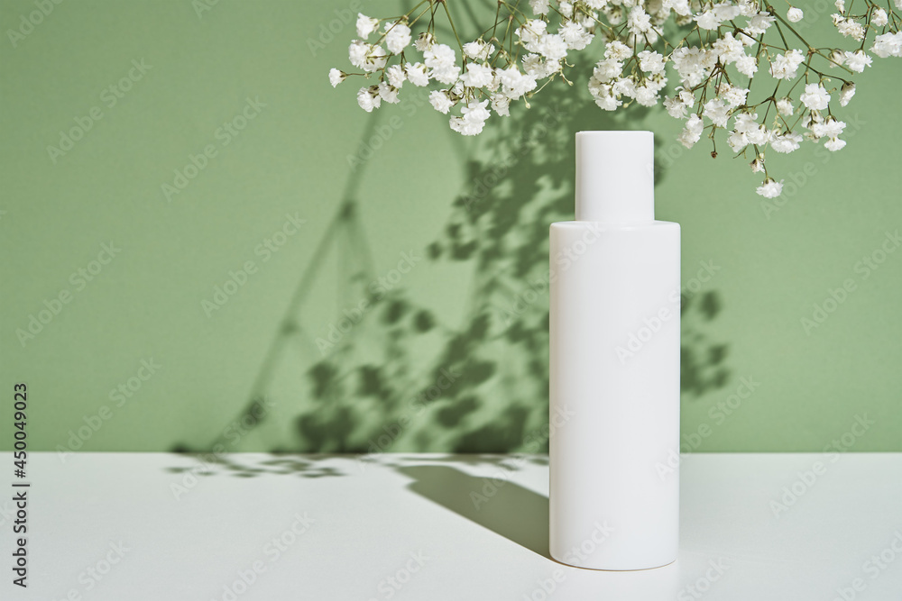 Beauty cosmetic product in white bottle on green background. Natural organic cosmetics Beauty cosmetic product in white bottle on green background. Natural organic cosmetics