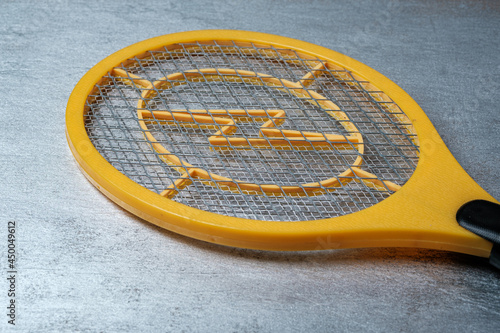 Electric fly swatter. A device for fighting flying insects in the form of a racket. Close-up. Selective focus photo