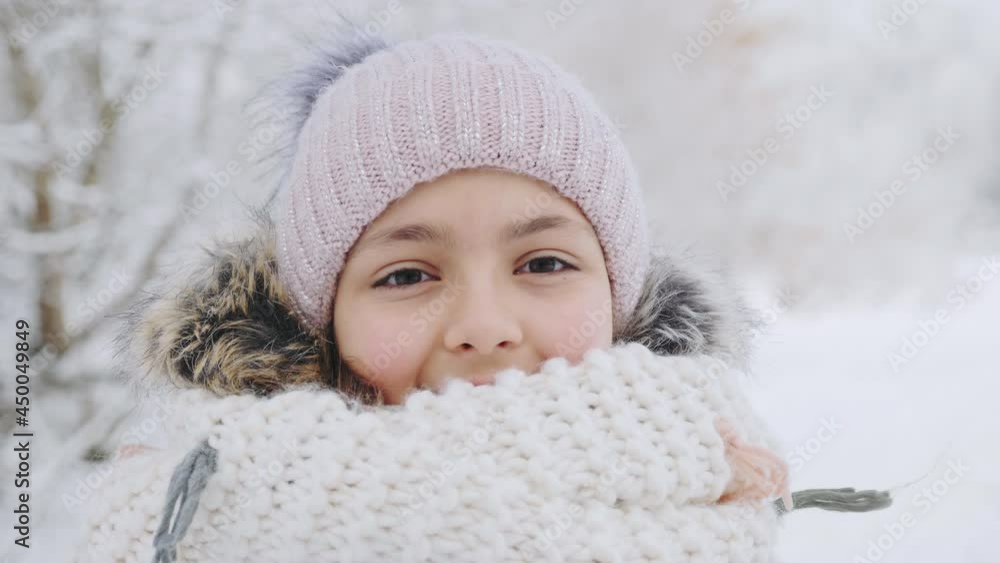 Portrait of a cute girl child in a warm knitted hat and scarf on a cold winter day Portrait of a cute girl child in a warm knitted hat and scarf on a cold winter day