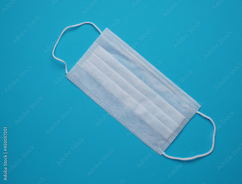 Medical mask on a blue background top view Medical mask on a blue background top view