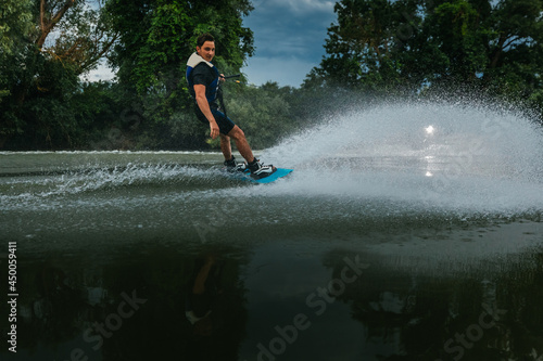 Wake-boarder surfing across a lake