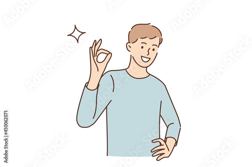 Ok sign and gesture language concept. Young smiling man cartoon character standing showing ok sign with fingers looking at camera vector illustration 