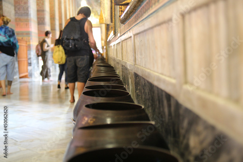 Donating coins in Wat Pho temple for luck and prosperity, Bangkok, Thailand photo