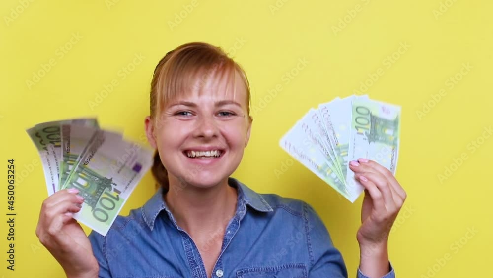 attractive woman with euro banknotes laughs and dances on a yellow background. surprise, win attractive woman with euro banknotes laughs and dances on a yellow background. surprise, win