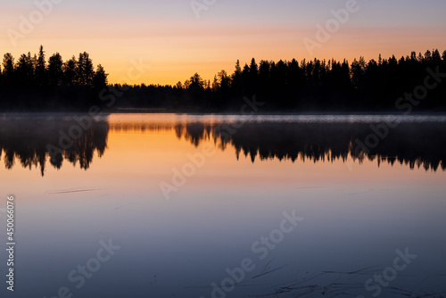 Colorful moody Sunset over lake with black silhouette of boreal forest  and beautiful reflection  Kitkaj  rvi  Posio  Finland