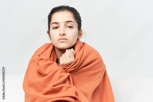 woman with a cold covered with a blanket at home treatment of infection