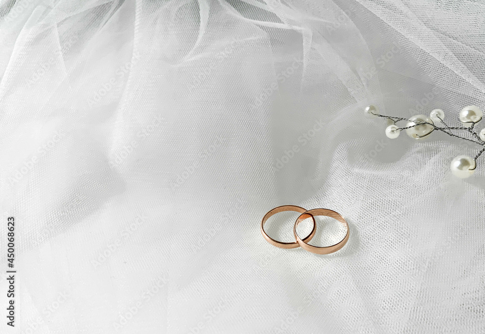 Flat lay background with a pair of gold rings and pearl necklace for wedding or engagement decorated with white lace of a veil of the bride, with copy space. Love concept, top view, lay out. Banner
Flat lay background with a pair of gold rings and pearl necklace for wedding or engagement decorated with white lace of a veil of the bride, with copy space. Love concept, top view, lay out. Banner
