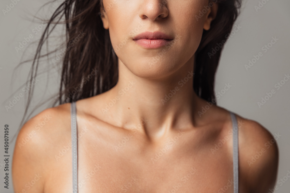 Cropped image of young beautiful arabian woman without makeup isolated over gray studio background. Natural beauty concept. Neck and shoulders Cropped image of young beautiful arabian woman without makeup isolated over gray studio background. Natural beauty concept. Neck and shoulders