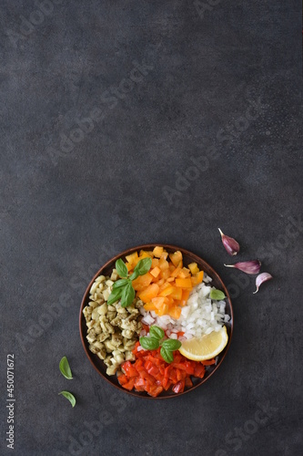 Salad with baked vegetables. Asian salad with eggplant, chili and garlic. On a black concrete background.
