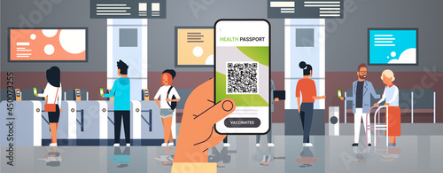 hand holding smartphone with digital immunity passport with qr code on screen risk free covid-19 pandemic