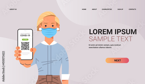 woman in mask holding digital immunity passport with qr code on smartphone screen risk free covid-19 pandemic