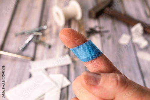 Finger of a caucasian man with a blue band-aid