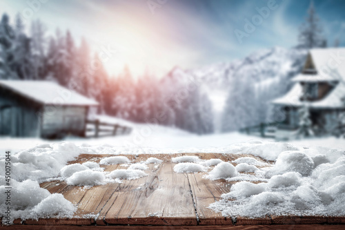 Fresh snow on a wooden table on a beautiful winter day with a landscape background 