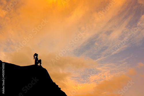 girl sitting on top of the mountain photo