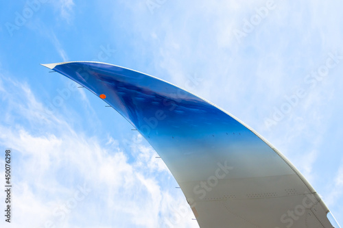 Winglet on a background of blue sky and clouds, pointed end of the wing.