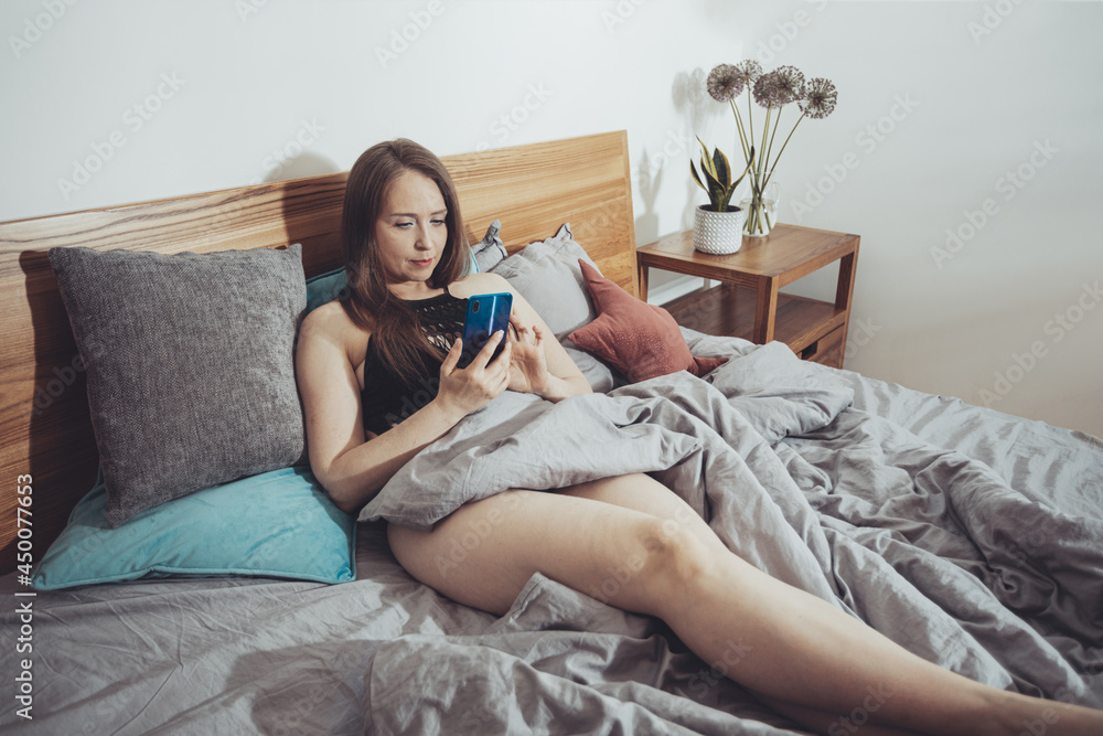 Beautiful woman reading, sitting in comfortable bed Beautiful woman reading, sitting in comfortable bed