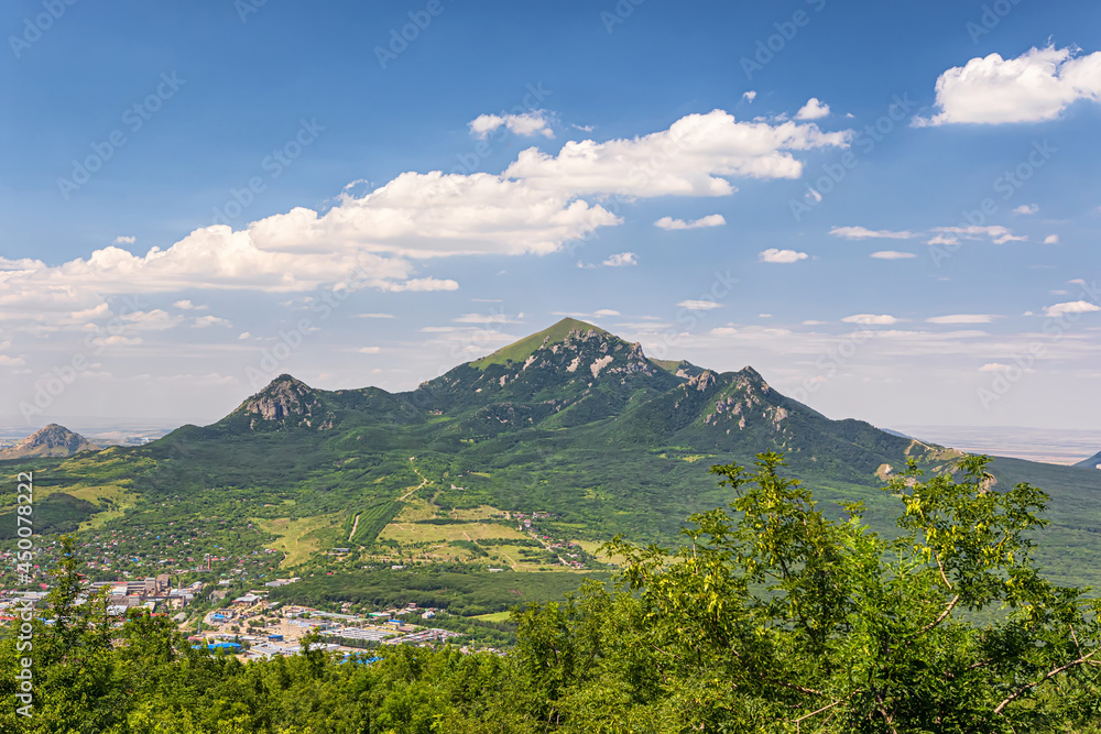 View of the Beshtau mountain, the city adjacent from below and fluffy clouds in the sky