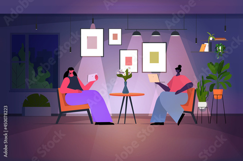 women using laptop and tablet pc in dark night living room social media network online communication concept