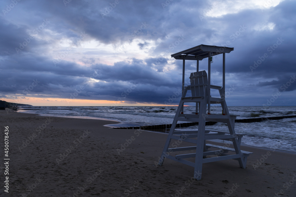 cloudy sunset over the sea and lifeguard stand