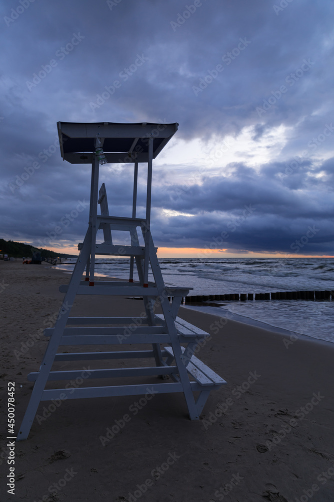 cloudy sunset over the sea and lifeguard stand