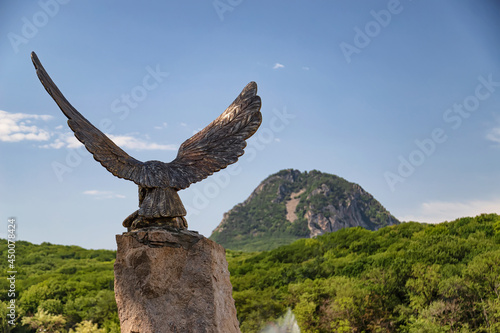 Bronze statue of the eagle on background of mountains