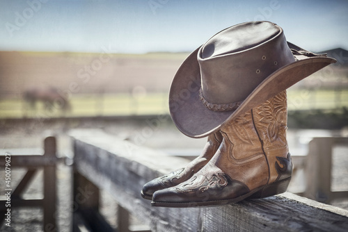 Cowboy hat and boots at ranch stables, country music festival live concert or line dancing concept photo