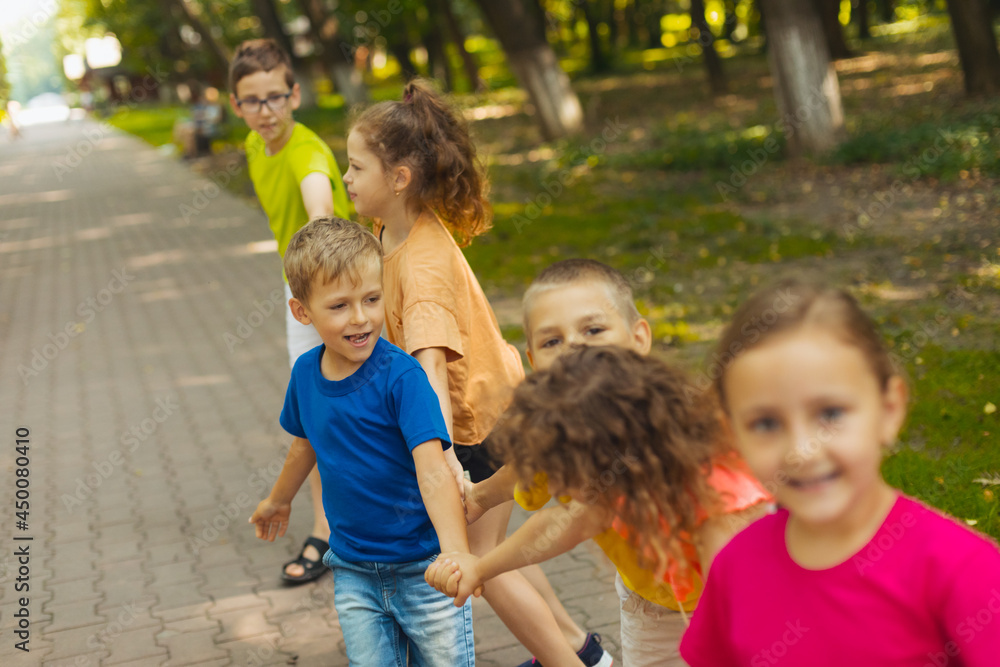 Cute boy playing with friends outdoors in the park Cute boy playing with friends outdoors in the park