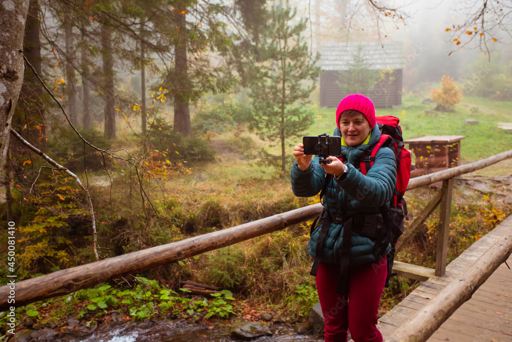 Fototapeta premium Woman is taking a selfie while hiking in the forest