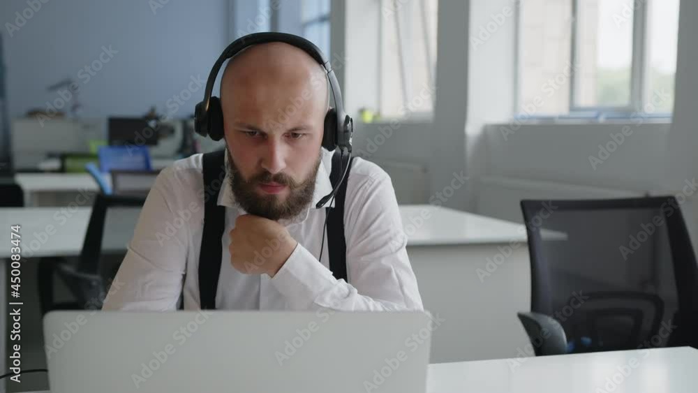 Online worker scratches his black beard and looks up Online worker scratches his black beard and looks up