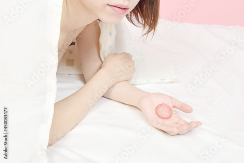 Obraz na płótnie コンドームを持つ若い女性 